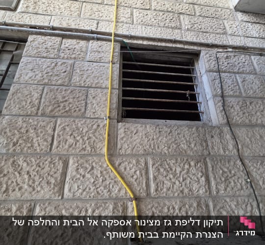 צינור גז צהוב מותקן על קיר אבן חיצוני